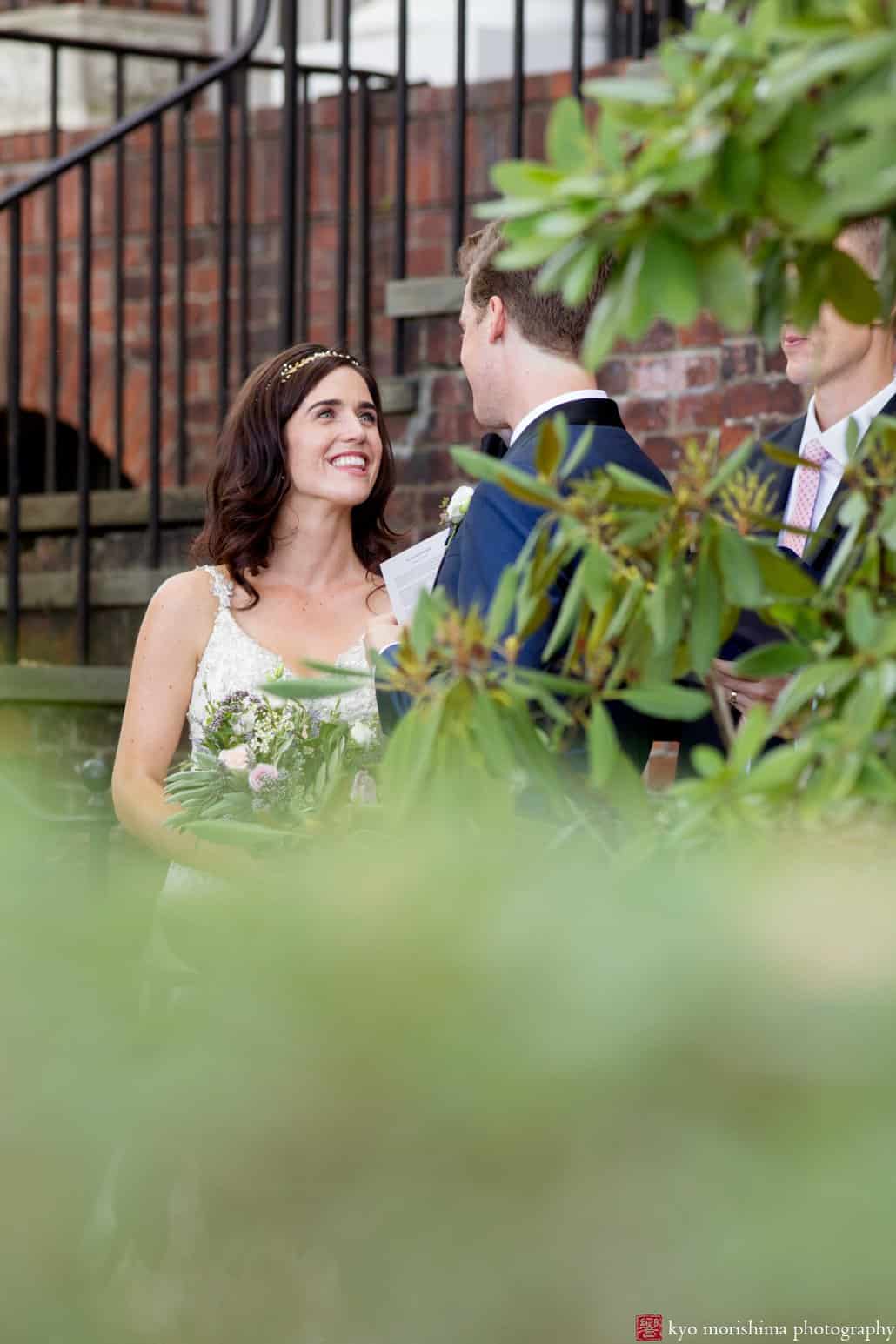 Bride smiles up at groom during outdoor wedding ceremony at Governors Island, photographed by Kyo Morishima