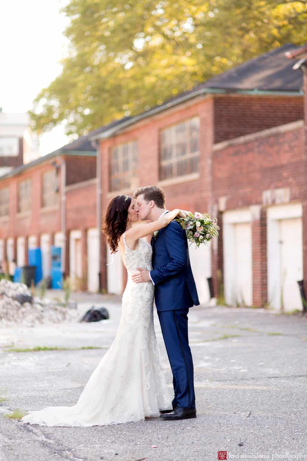 Bride and groom kiss in a Governors Island alleyway, photographed by Kyo Morishima