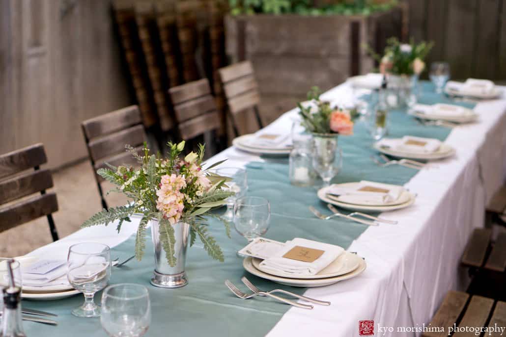 Table at Frankies 457 Spuntino wedding set with white tablecloth and teal blue silk runner; pale pink and peach bouquets by Opalia Flowers, photographed by Kyo Morishima