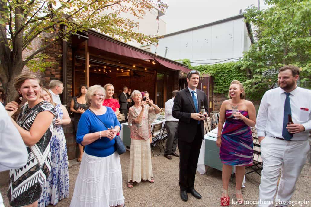 Guests applaud as bride and groom arrive for wedding reception at Frankies 457 Spuntino, photographed by Kyo Morishima