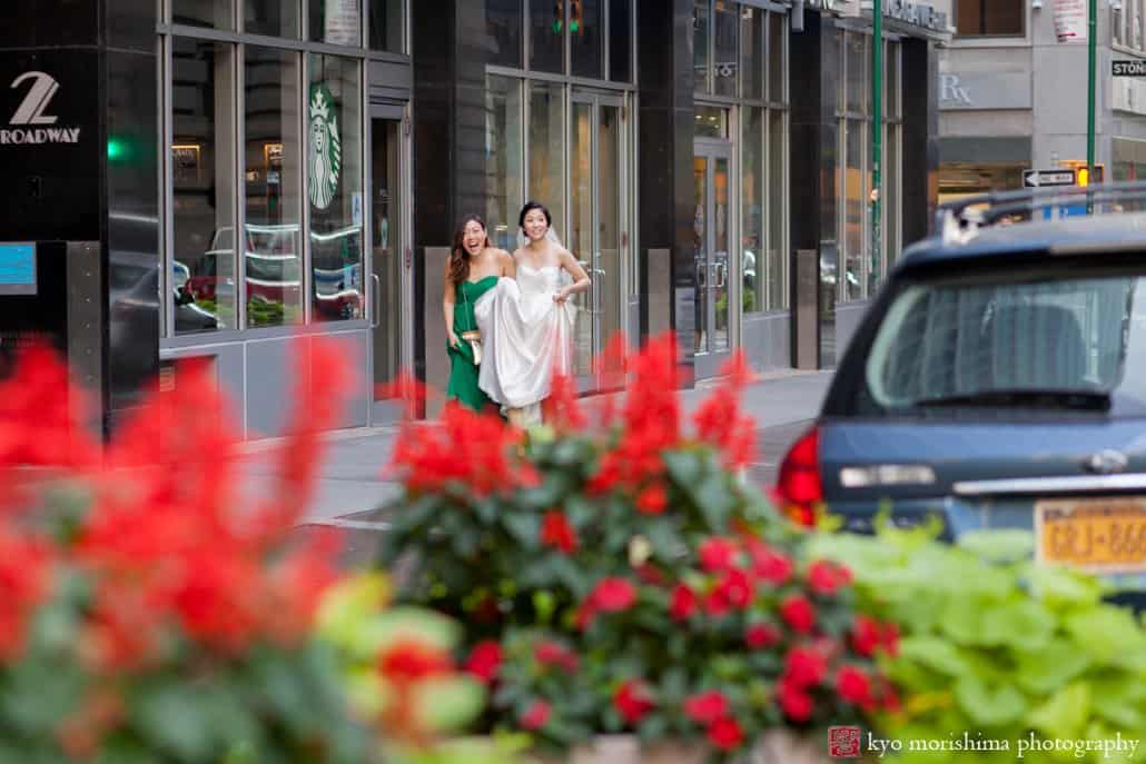 Bride and bridesmaid walk down a street in Lower Manhattan, photographed by Kyo Morishima