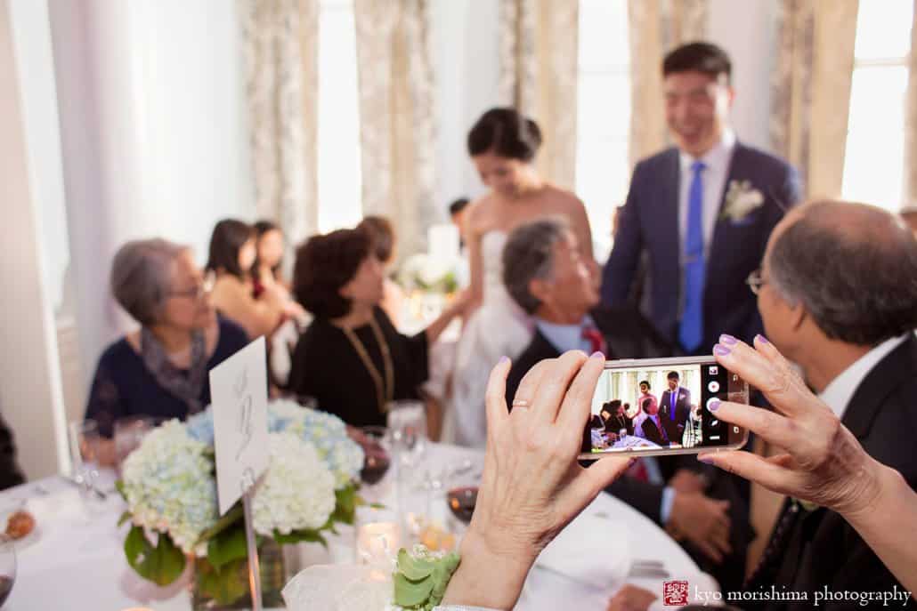 Guest snaps a photo of bride and groom greeting guests during Korean wedding in Lower Manhattan, photographed by Kyo Morishima