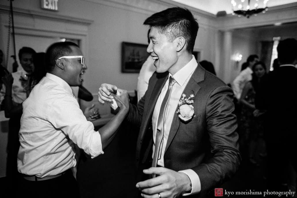 Korean groom shakes hands with guest during India House wedding reception photographed by Kyo Morishima