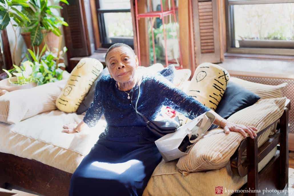 Godmother of the groom relaxes on a sofa in Harlem brownstone, photographed by Carlo Cipriani for Kyo Morishima Photography