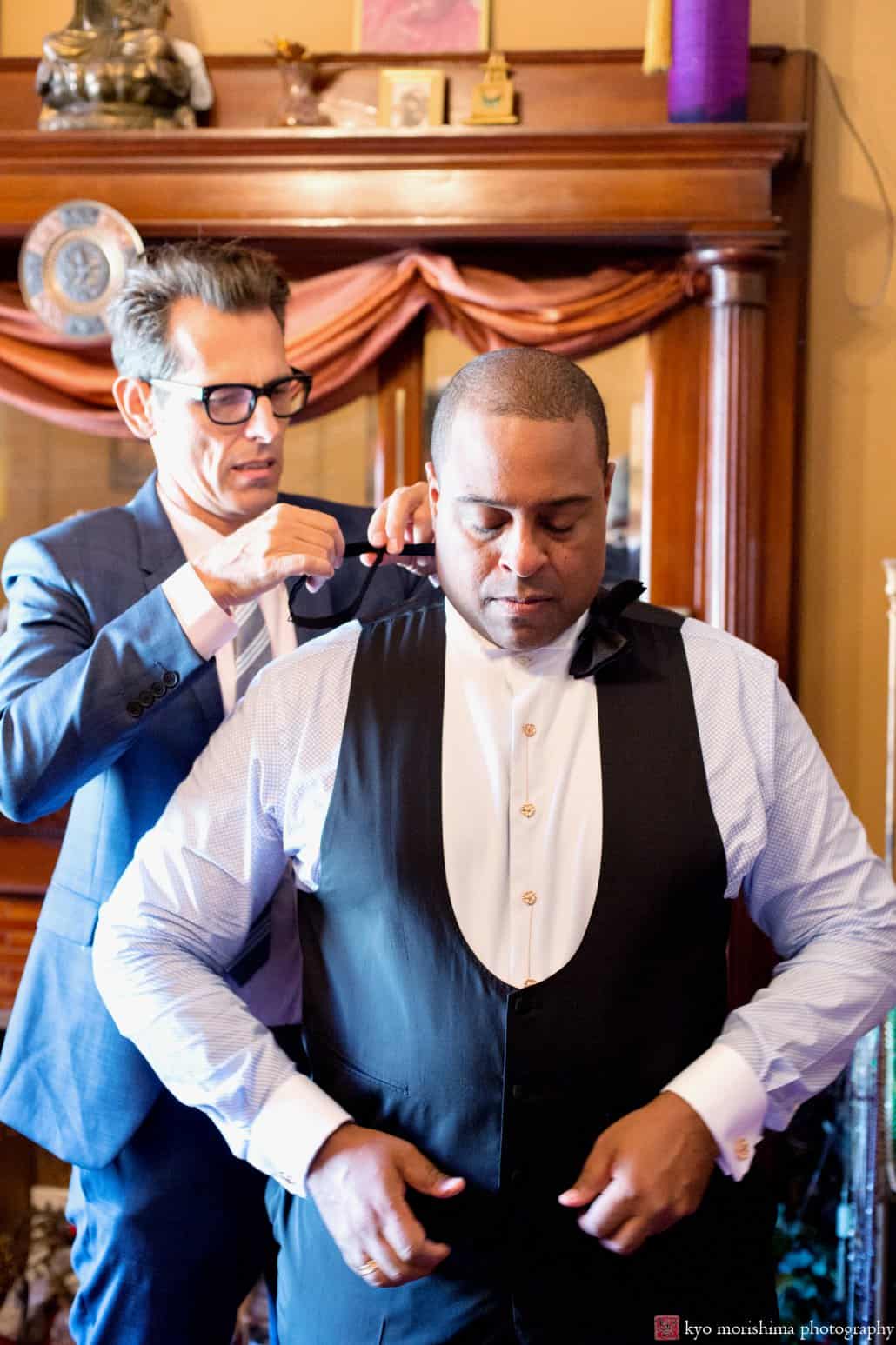 Friend helps groom get ready in his Harlem brownstone, photographed by Carlo Cipriani for Kyo Morishima Photography