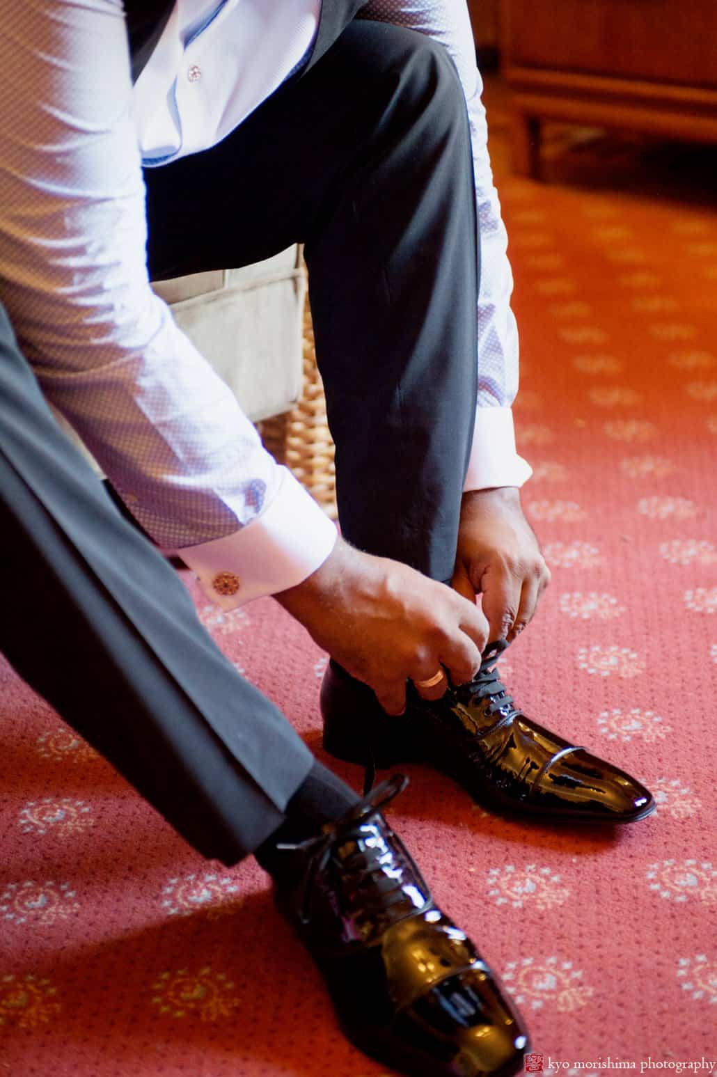 Groom ties his shoelaces in Harlem brownstone, photographed by Carlo Cipriani for Kyo Morishima Photography