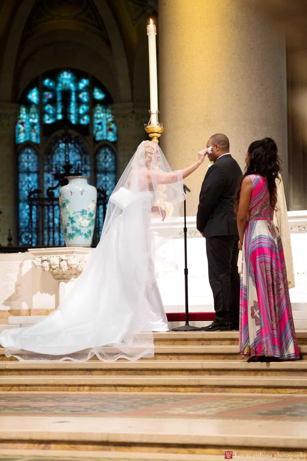 Bride wipes away groom's tear during St. John the Divine wedding ceremony