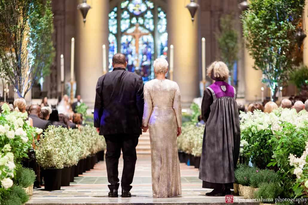 Groom and mother of the bride walk down the aisle together during St. John the Divine wedding ceremony