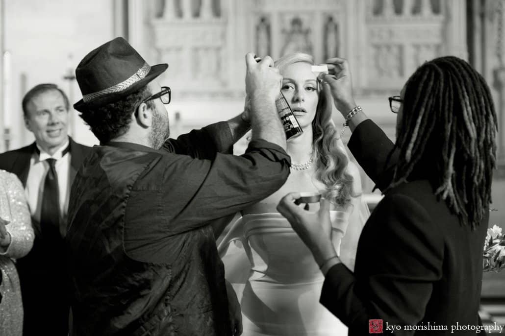 Makeup artists from Once Upon a Bride fix bride's makeup before portrait session at St. John the Divine