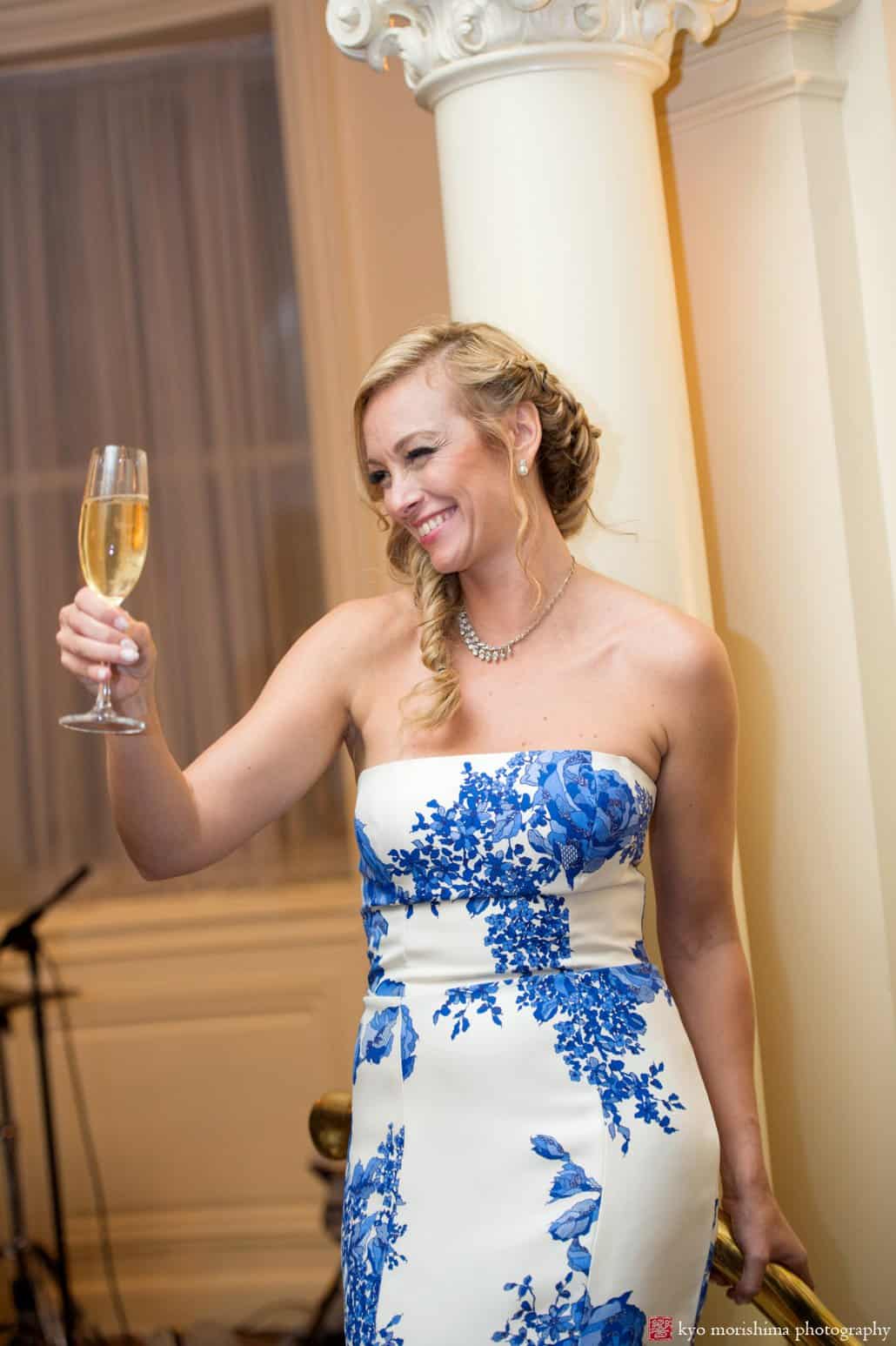 Bride wearing blue and white rose printed Monique Lhuillier wedding dress raises a toast at Lotos Club wedding on the Upper East Side, photographed by Kyo Morishima