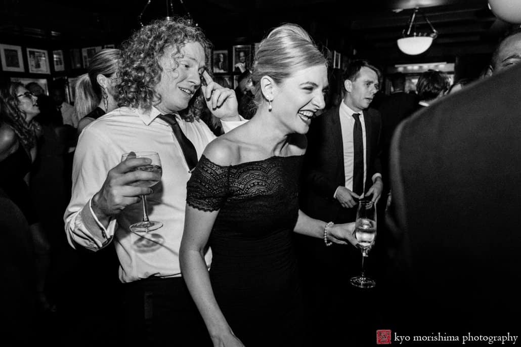Guests laugh during after party in The Grill Room at The Lotos Club, photographed by Upper East Side wedding photographer Kyo Morishima