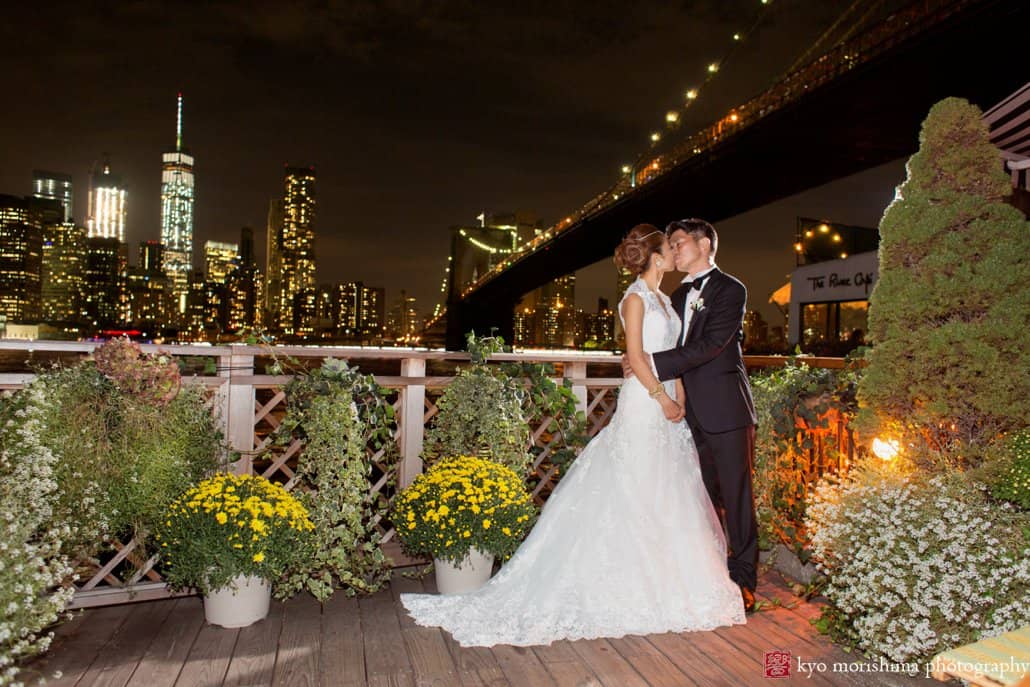 Bride and groom kiss on the patio after River Cafe wedding, photographed by Kyo Morishima