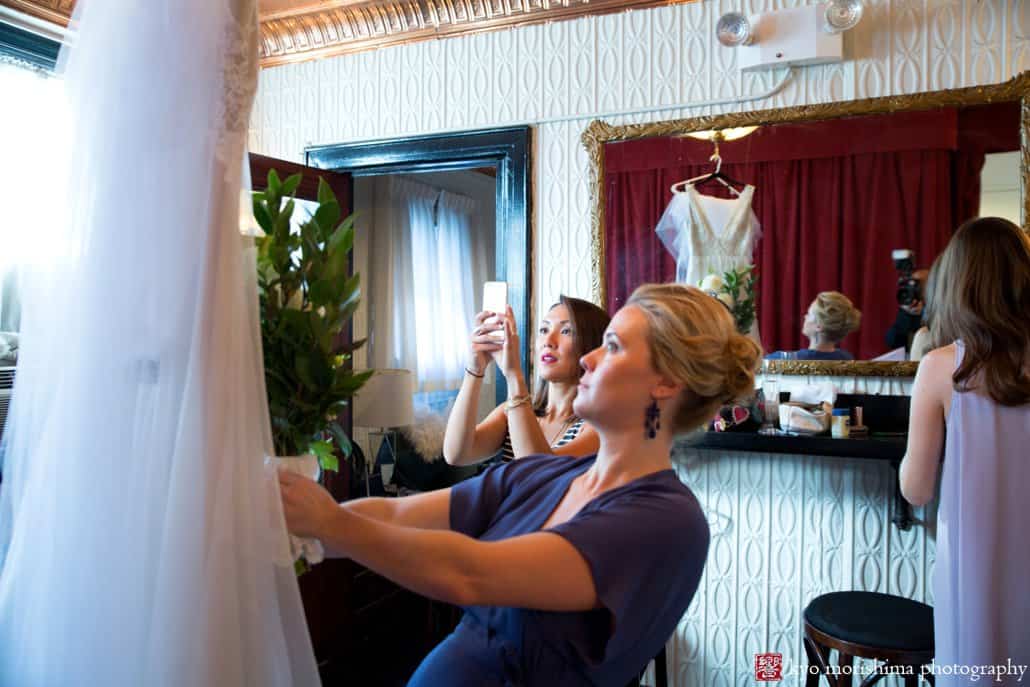 Bridesmaids inspect wedding dress at the Green Building in Brooklyn, photographed by Kyo Morishima