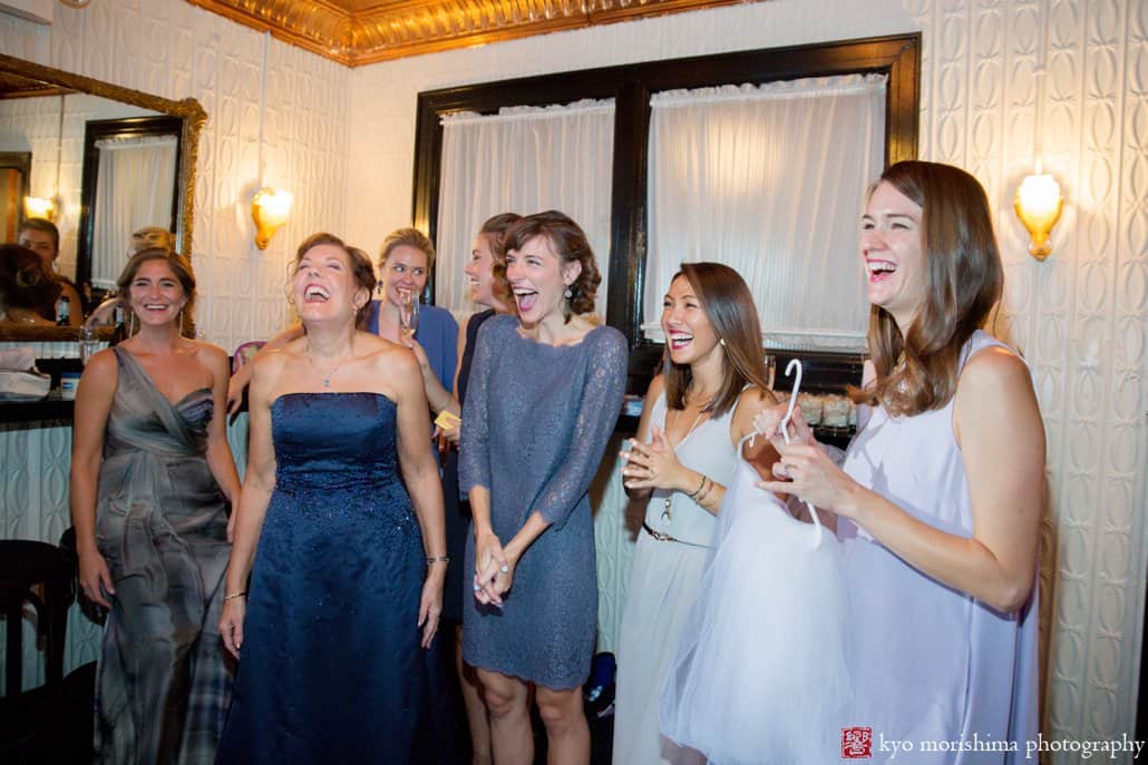 Bridesmaids and friends laugh while bride gets ready before Green Building wedding in Brooklyn, photographed by Kyo Morishima