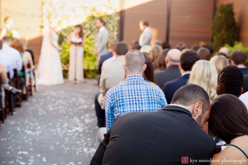 Guests watch Green Building wedding in outdoor courtyard in Brooklyn, photographed by Kyo Morishima