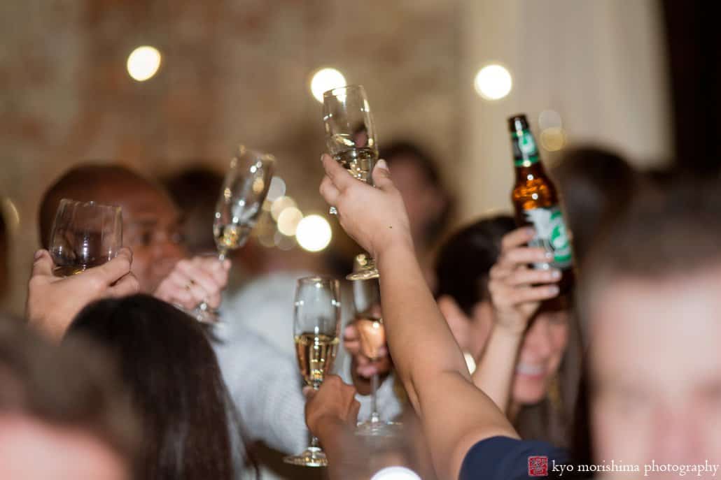 Guests raise glasses for a toast during Green Building wedding, photographed by Kyo Morishima