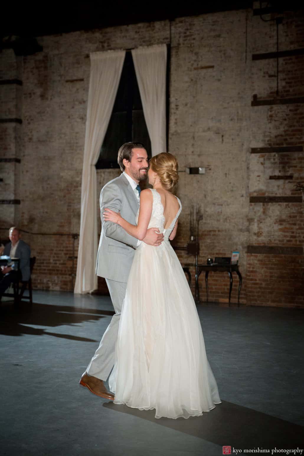 Bride (wearing Shareen Bridal gown) and groom begin their first dance at industrial-style wedding in the Green Building, Brooklyn, photographed by Kyo Morishima
