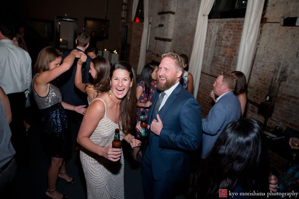 Guests dance to music by DJ OP! at industrial-style Green Building wedding in Brooklyn, photographed by Kyo Morishima