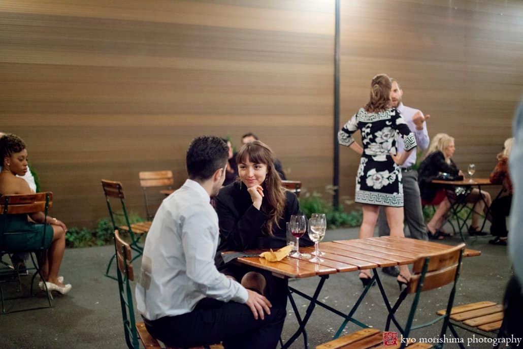 Guests chat outside at night as wedding nears end at Brooklyn intimate wedding venue The Green Building, photographed by Kyo Morishima