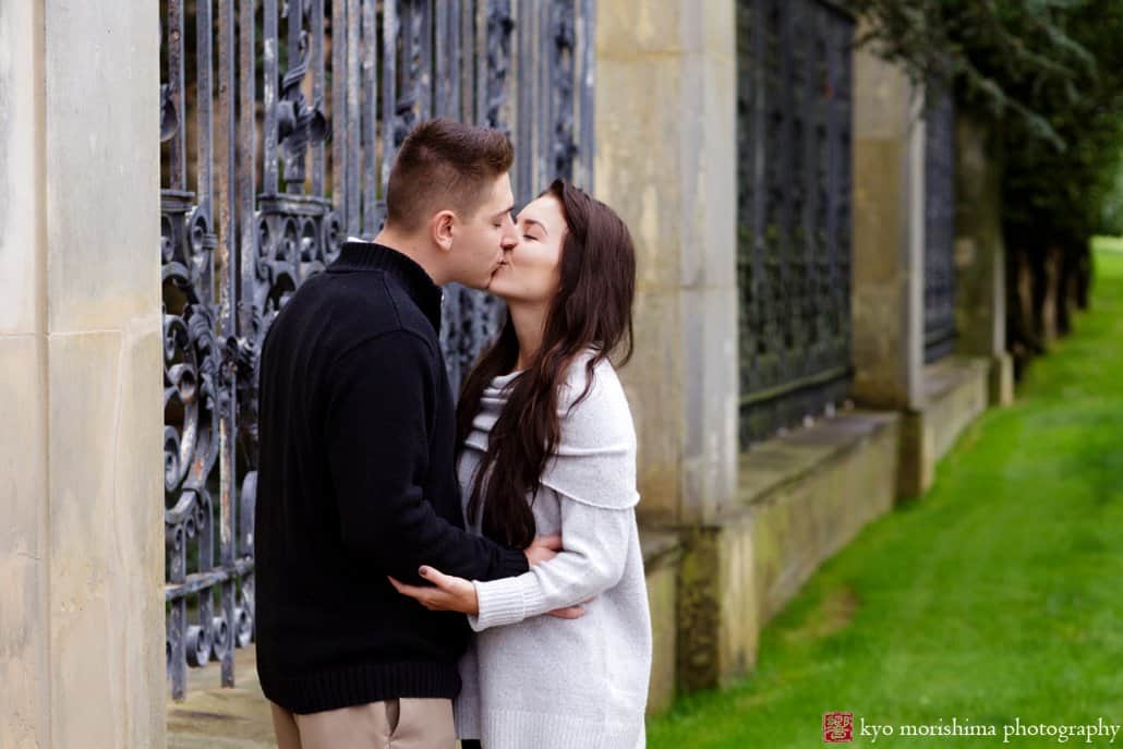Princeton engagement photos: a couple kisses at the front gates of the Jasna Polana mansion, photographed by Princeton wedding photographer Kyo Morishima