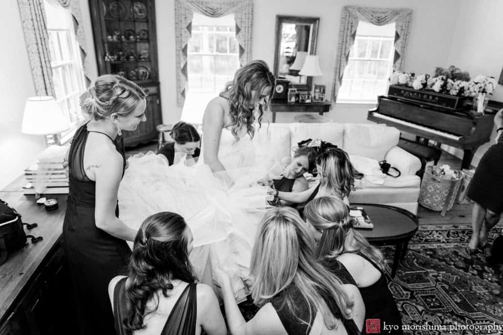 Bride puts on Pronovias wedding gown, surrounded by bridesmaids in the living room