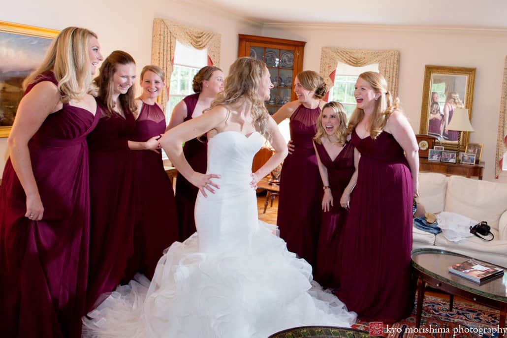 Bride wearing Pronovias laughs with bridesmaids wearing Amsale just after they've finished getting ready in Princeton living room