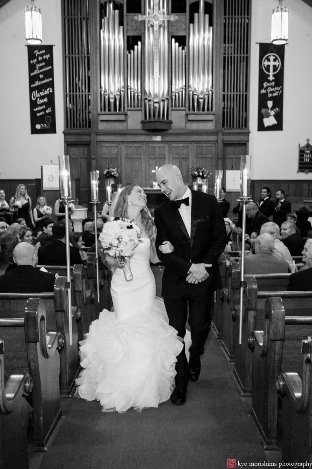 Bride and groom glance happily at each other as they depart Princeton United Methodist Church wedding