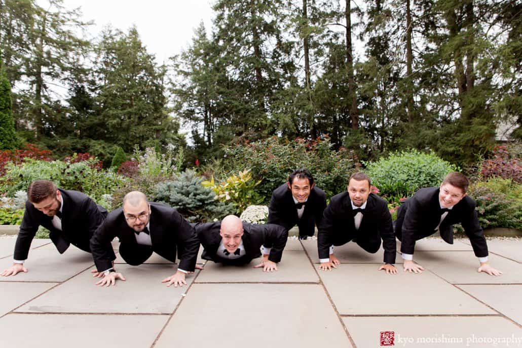 Groom and groomsmen do push-ups during wedding portrait session at Princeton's Prospect Gardens