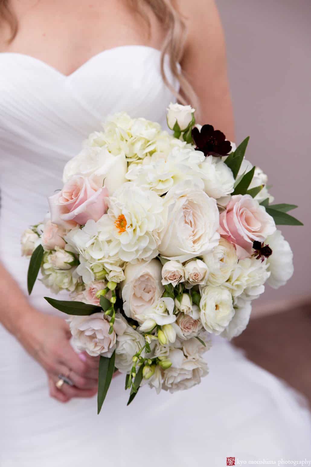 Bride holds white and pale pink rose wedding bouquet by Princeton florist Viburnum