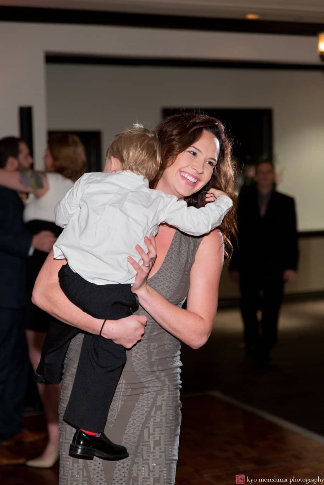 Mom carries tired ring bearer during Cherry Valley Country Club wedding reception