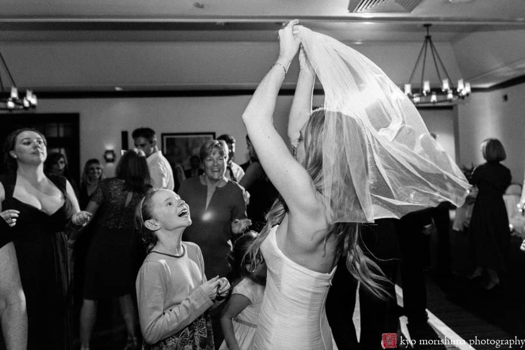 Bride goofs off with young guest during Cherry Valley Country Club October wedding reception