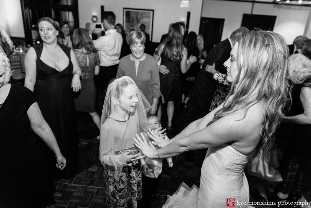 Bride and young guest dance together to music by 74 Events at Princeton wedding reception at Cherry Valley Country Club