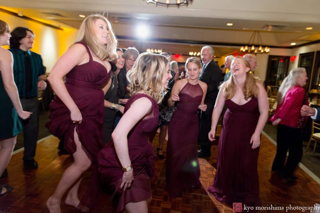 Bridesmaids wearing maroon Amsale dresses dance riotously during Cherry Valley Country Club wedding reception