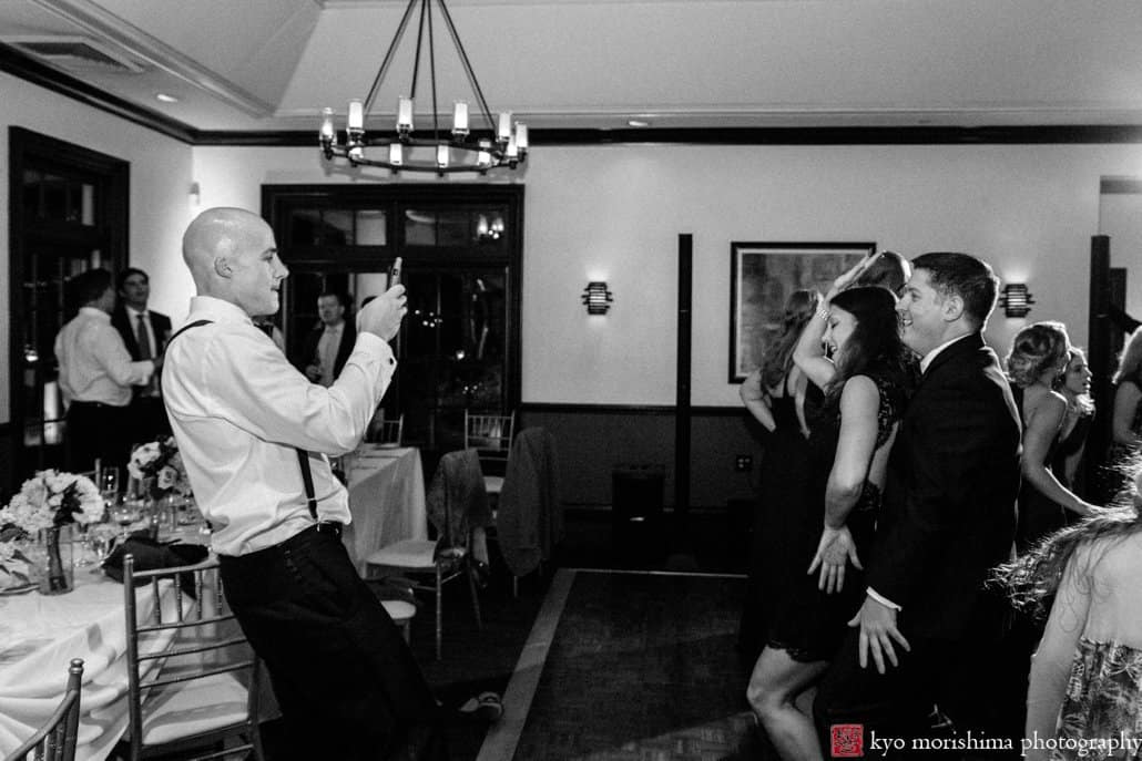 Groom photographs wedding guests cavorting during Cherry Valley Country Club reception