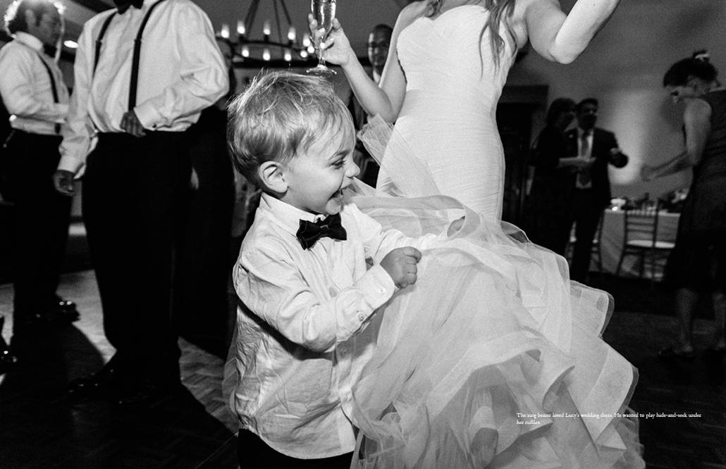 Ringbearer plays hide and seek in the ruffles of bride's Pronovias wedding gown