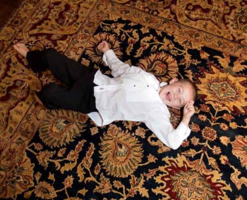 Ring bearer rolling around on a floor during fall Jasna Polana Princeton NJ wedding reception