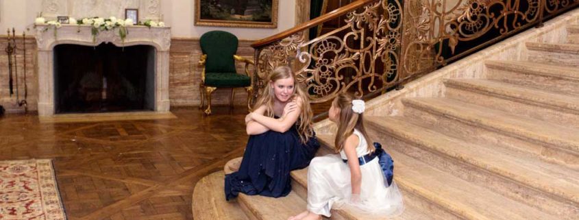 Flower girl and bridesmaid talking at a steps during fall Jasna Polana Princeton NJ wedding reception
