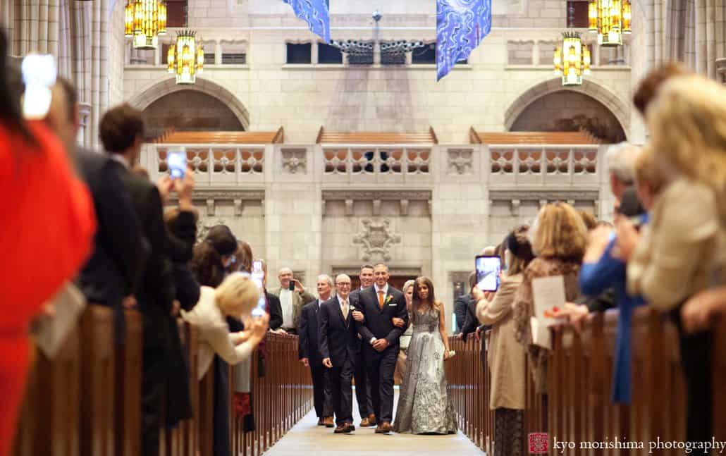 Groom walks down the aisle flanked by parents during Princeton University Chapel wedding