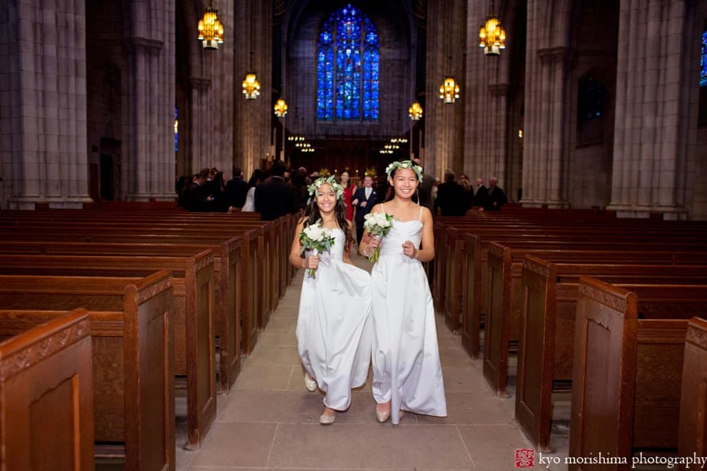 Flower girls wearing flower wreaths depart Princeton University Chapel wedding ceremony