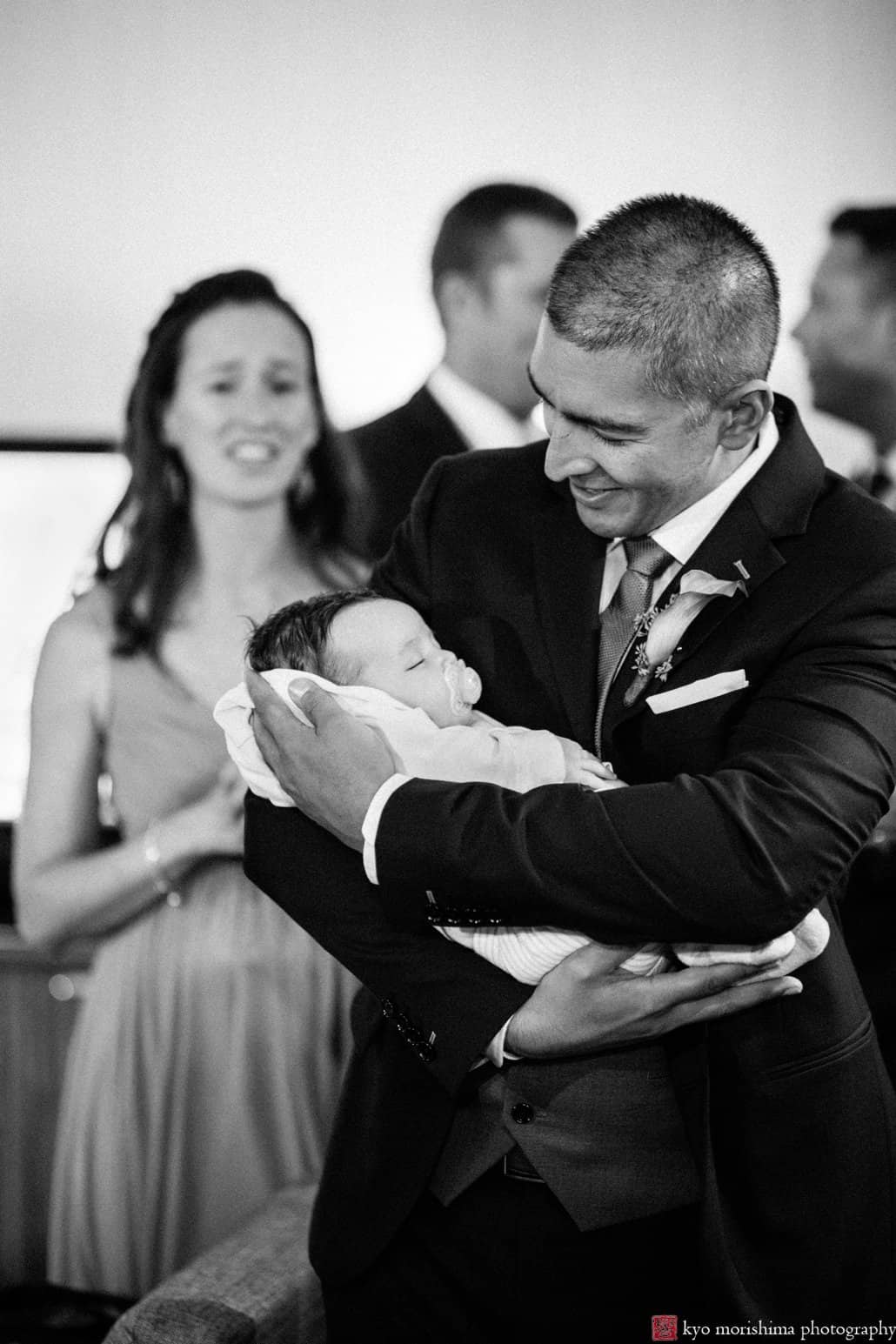 Groom holds newborn baby at Hyatt Regency Princeton wedding reception