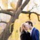 Engagement photo kiss with yellow-leaved willow tree in the background at Central Park