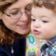Candid family photographer central New Jersey: child blows bubbles with mom