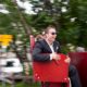 Wedding guests take a ride on red seats in Swiss Alps for European destination wedding photography. Motion photography.