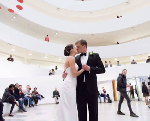 Bride and Groom kiss in middle of Guggenheim where they had their first date. Veka Bridal wedding dress. Black tux. New York wedding photographer. Guggenheim NYC wedding