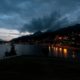 Night photography on Lake St. Moritz at European destination wedding in Switzerland, village on mountainside, cloudy skies, evening wedding photo.
