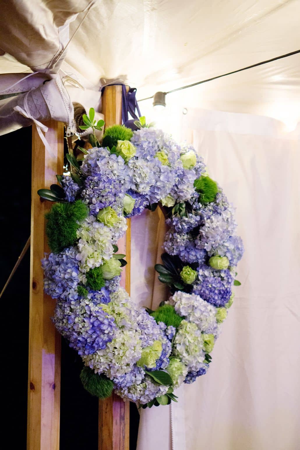 Blue and green wedding wreath with hydrangea, roses, in wedding tent, Dahlia's Florist, Spring Lake NJ, wedding photographer.