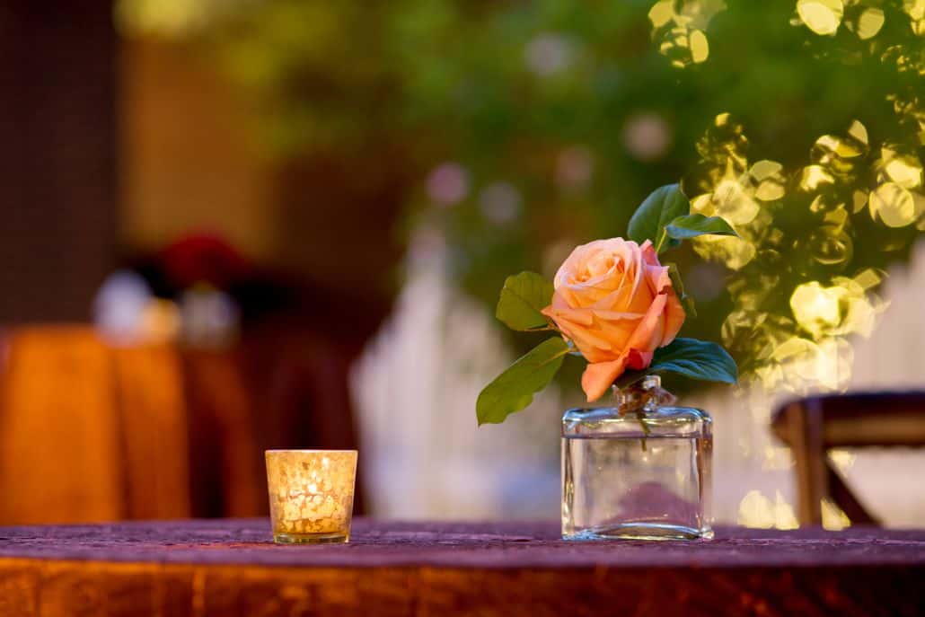 Peach rose in bud vase for wedding table decor, mercury glass tea light holder, burnt orange crushed silk tablecloth, dark wood chairs, Kristin Rockhill florist, Nassau Inn, Princeton, NJ wedding photographer.