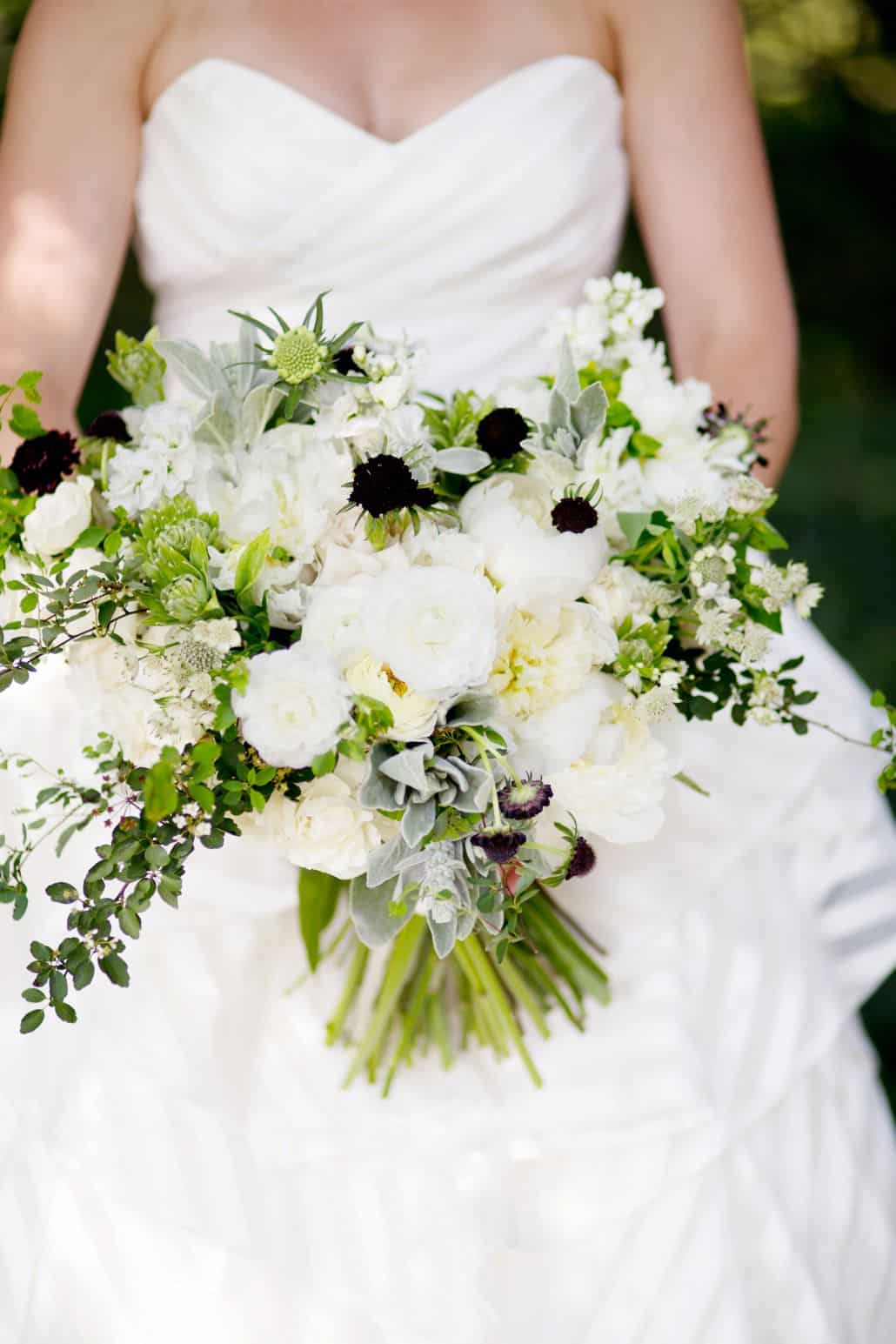 bride holds natural, flowing, cream sage and dark purple bridal bouquet in her lap. Katherine Toland florist, Jasna Polana Princeton NJ wedding photographer.