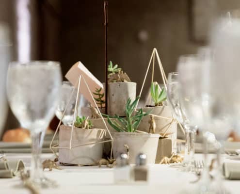 succulents in hupertufa pots surrounded by wooden matchstick frames as wedding table centerpiece. tiny gold dinosaurs, Front and Palmer Phiadelphia PA wedding photographer.