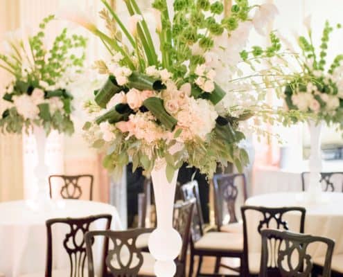 tall peach and green wedding table centerpieces with roses, bells of ireland, calla lilies, eucalyptus, hydrangea at lotos club NYC, Franz James florist, black dining chair and white table cloths with tea lights. New York Wedding photographer.